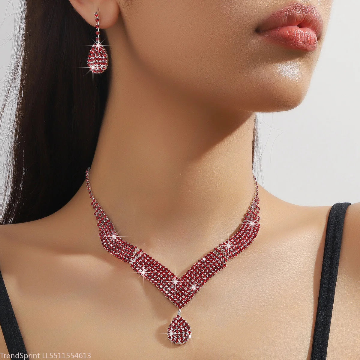 Fashion jewelry set with drop-shaped rhinestones, featuring earrings and necklace in gold-tone, by Corporación Turística.