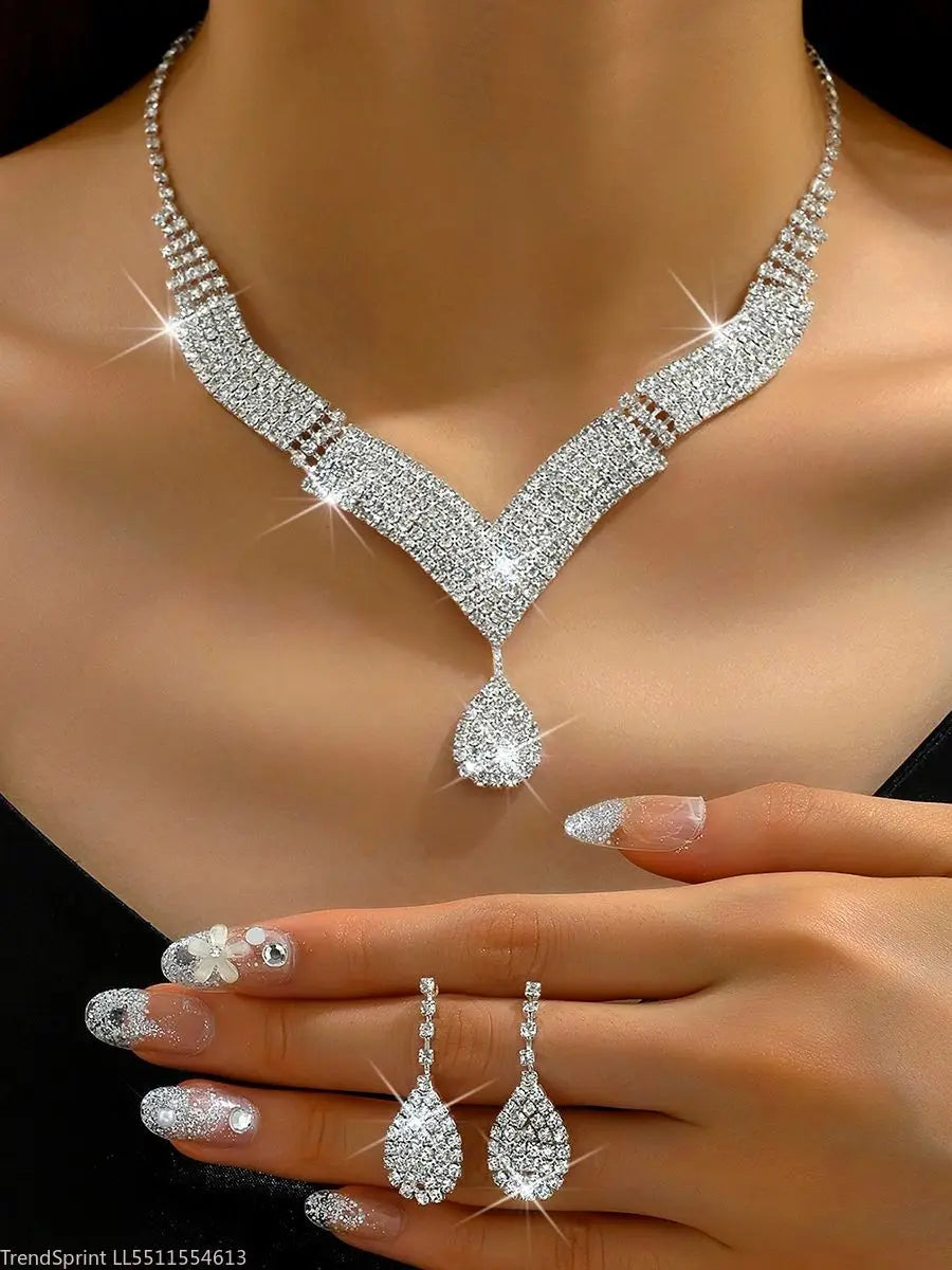 Fashion jewelry set with teardrop-shaped rhinestones, featuring gold-tone finish and elegant design by Corporación Turística.