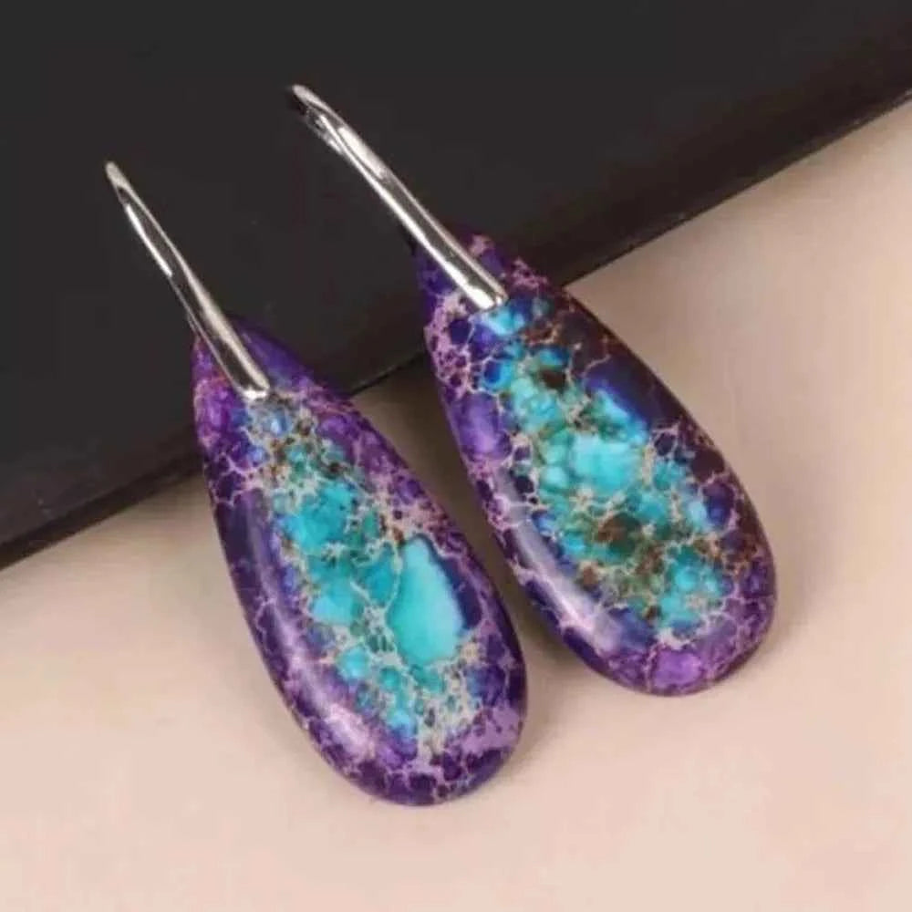 Natural jasper stone pendant earrings with teardrop shape, crafted by Corporación Turística, hanging from silver hooks.