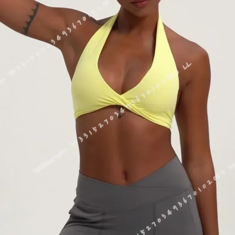 Black women's yoga sports bra with halter neck from Corporación Turística, shown on a model in a fitness setting.