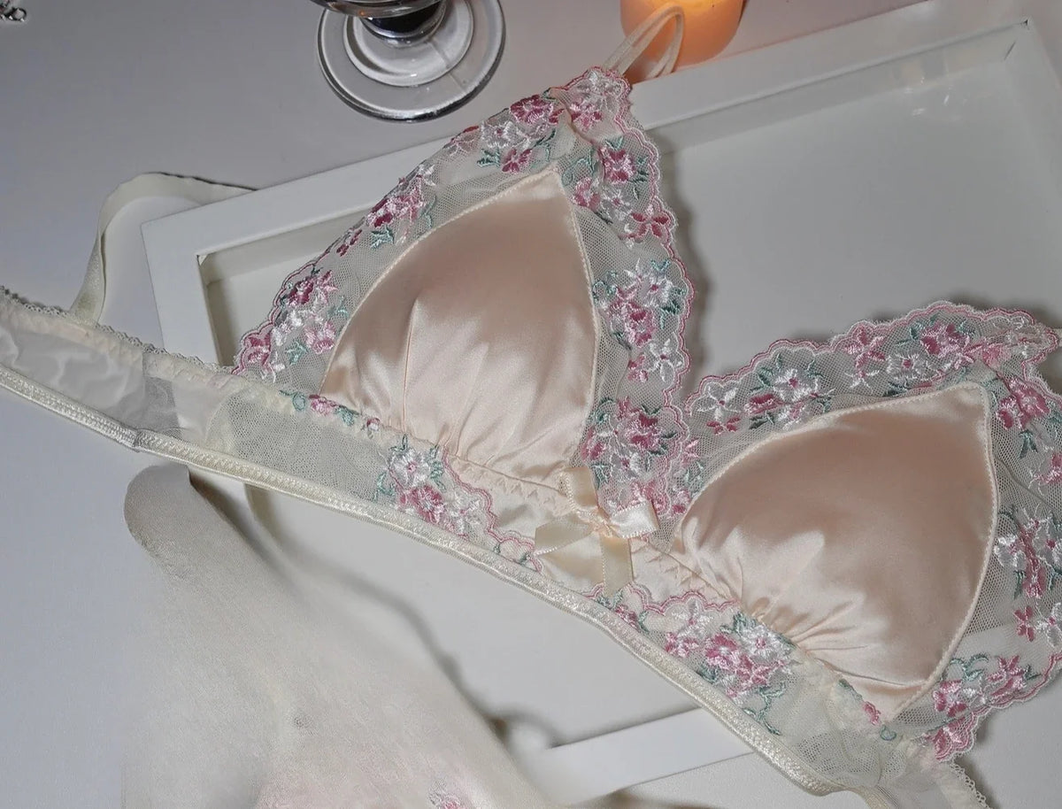Luxury silk lace lingerie set by Corporación Turística, featuring black lace and delicate fabric, displayed on a flat surface.