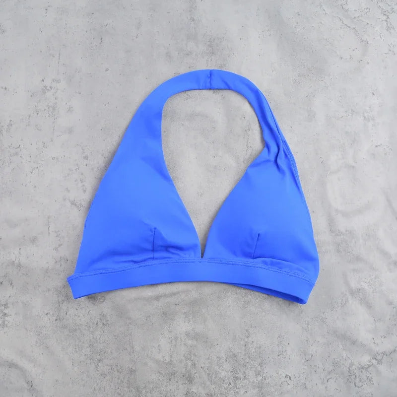 Light blue women's sports bra with halter neck design by Corporación Turística, showing the front view with supportive fabric.