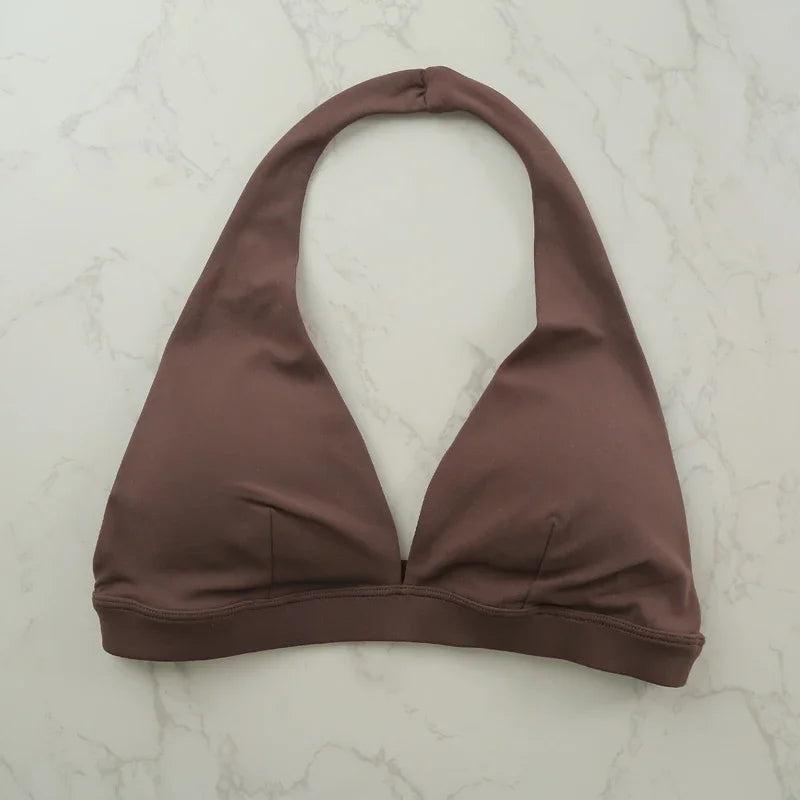 Light blue women's sports bra with halter neckline, by Corporación Turística, featuring a stylish and supportive design for active wear.