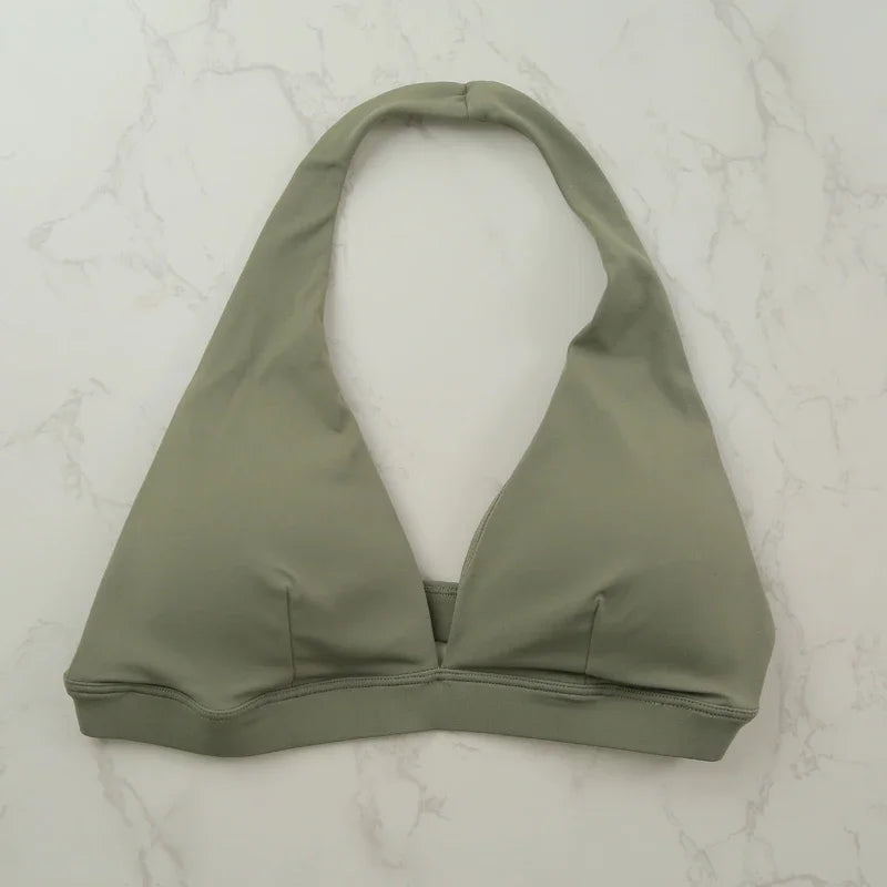 Light blue women's sports bra with halter neck design by Corporación Turística, shown on a plain background.