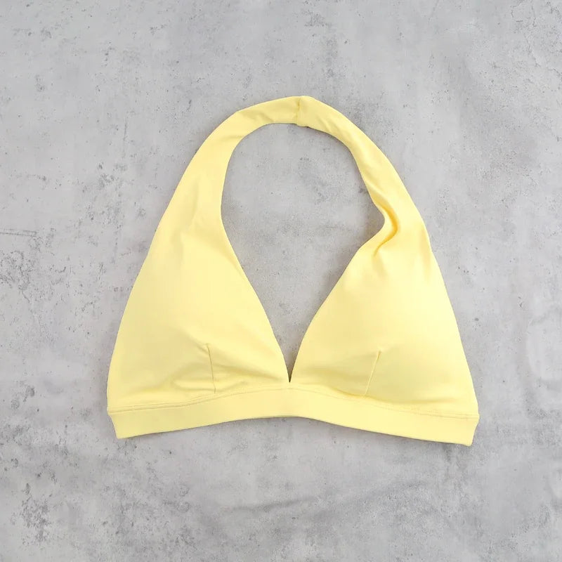 Light blue women's sports bra with halter neck design from Corporación Turística, shown on a mannequin.