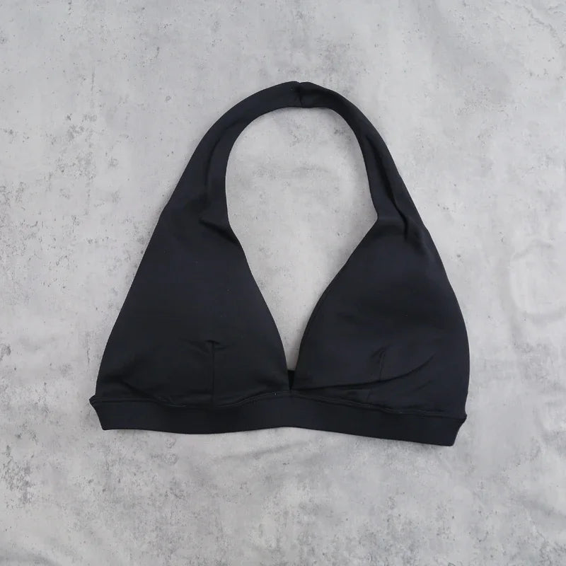 Light blue women's sports bra with halter neck design, from Corporación Turística, featuring supportive style for active wear.