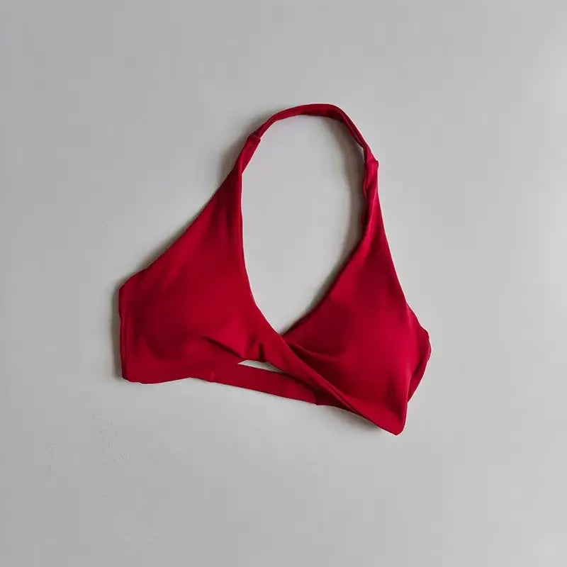 Scarlet red halter sports bra for women with open back, from Corporación Turística, shown on a model.