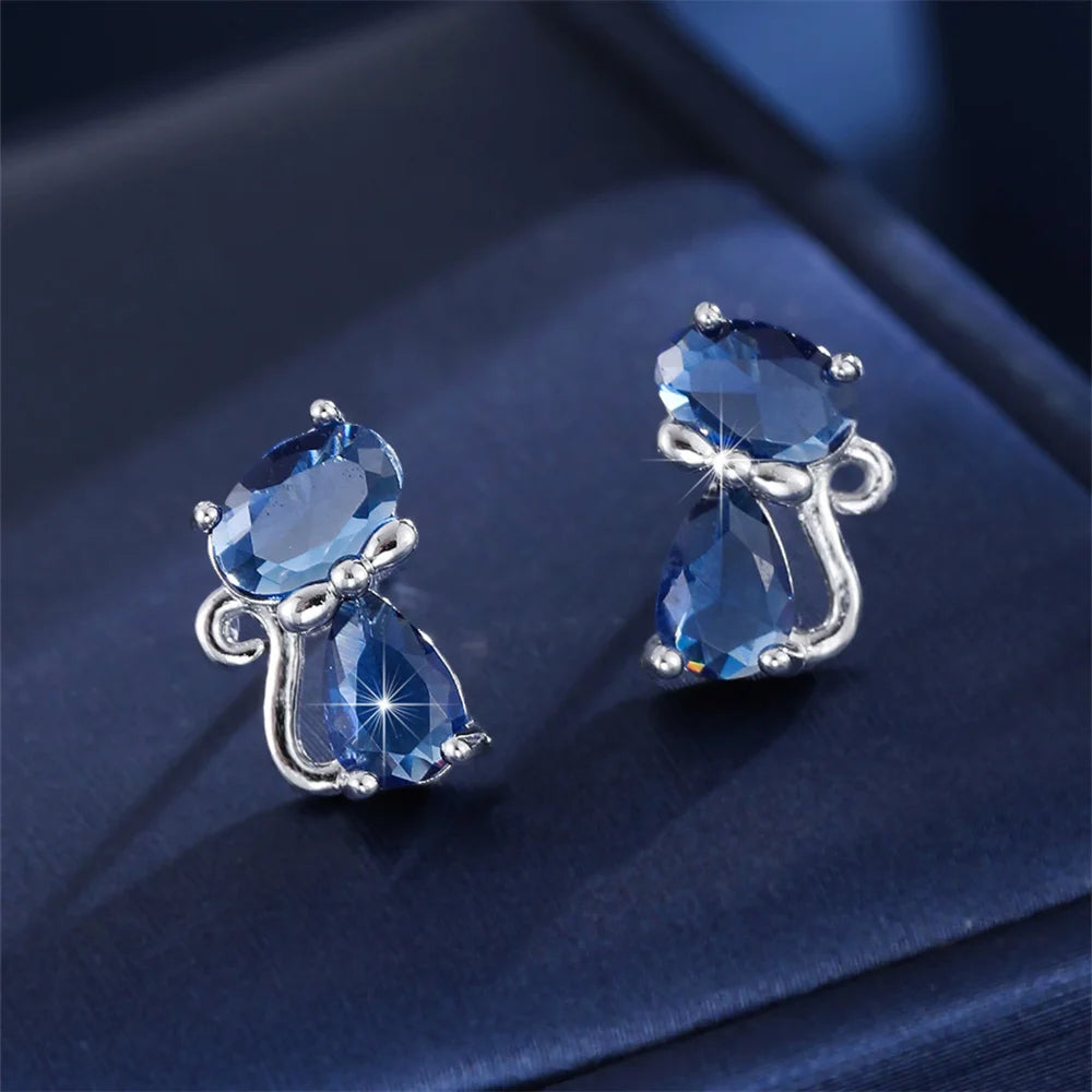 Small green cat-shaped earrings with zirconia stones, crafted by Corporación Turística.