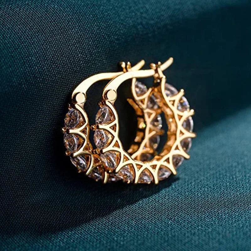 Stainless steel hoop earrings for women, stylish jewelry by Corporación Turística, featuring sleek gold-toned circular design.