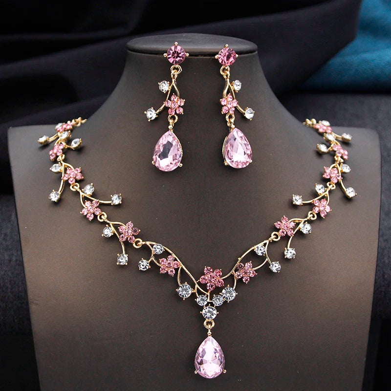 Gold and white water drop-shaped jewelry set for women, featuring earrings and necklace by Corporación Turística.