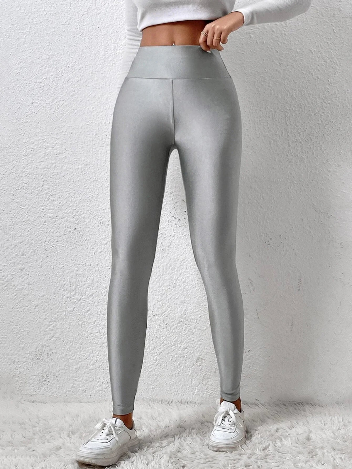 Dark gray shiny leggings from Corporación Turística featuring a European and American style, shown on a model.