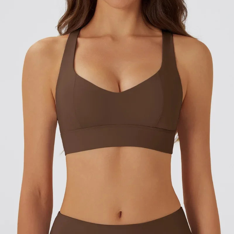 Dark gray women's yoga sports bra with padded cups, designed for comfort and support during exercise, by Corporación Turística.