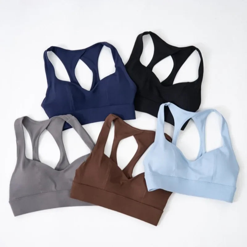 Dark gray women's yoga sports bra with padded support, designed for comfort during exercise, by Corporación Turística.