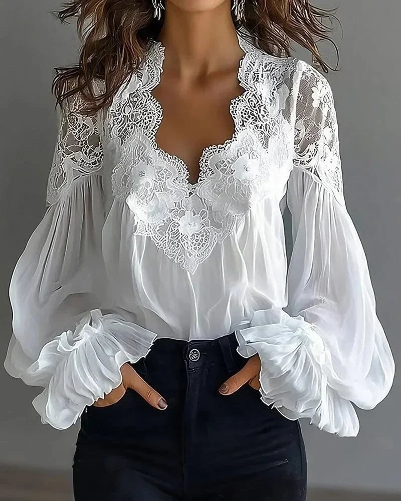 White lace blouse from Corporación Turística with deep V neckline and long sleeves, featuring elegant, detailed lace fabric.