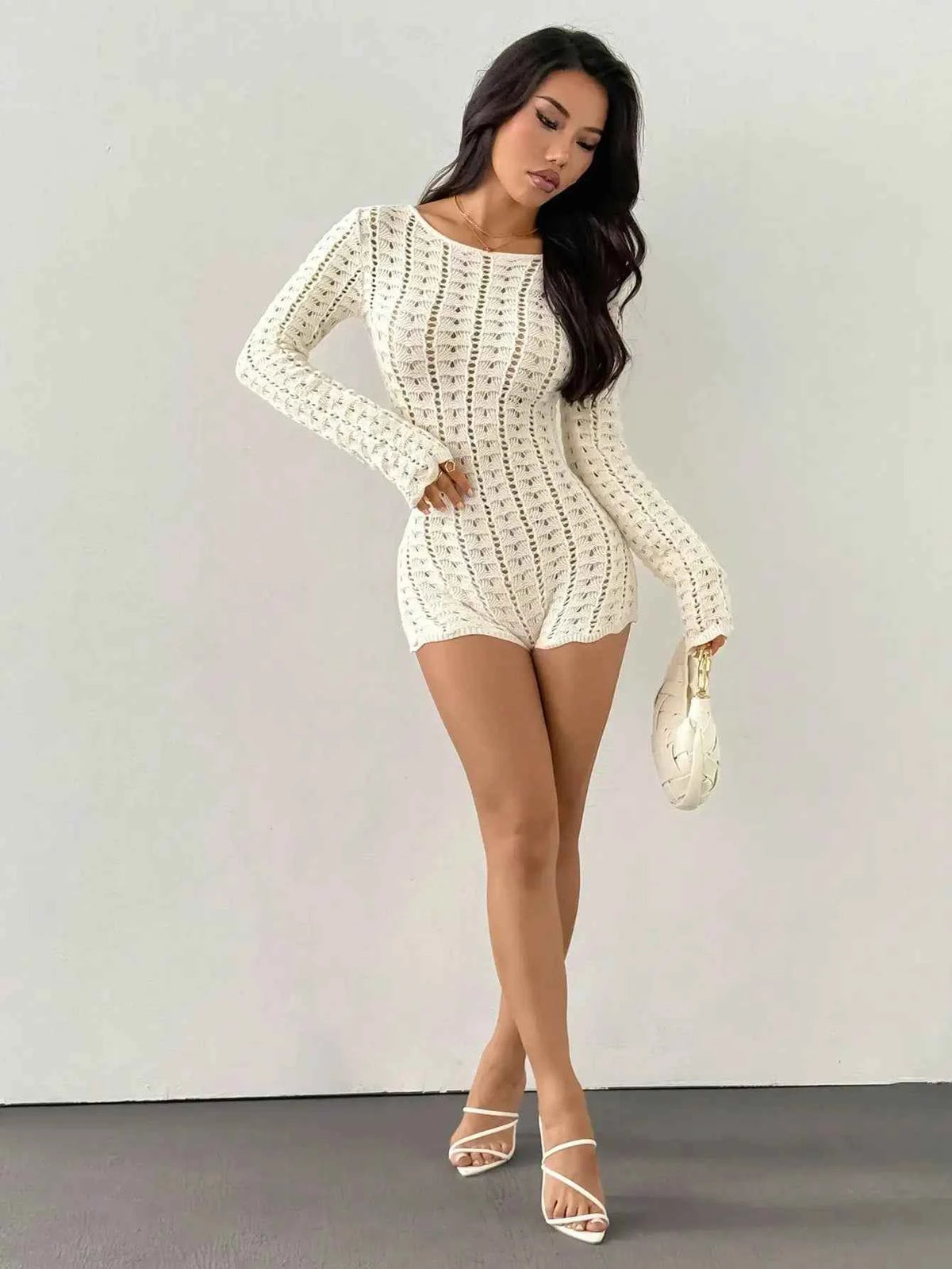 Marfil-colored women's short crochet knit jumpsuit with long sleeves, from Corporación Turística, displayed on a model.