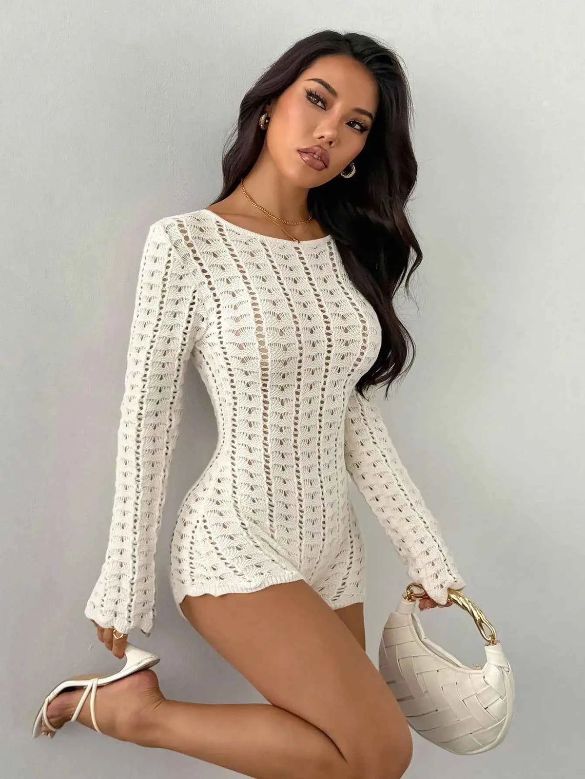 Marfil-colored women's short crochet knit jumpsuit with long sleeves, stylish and comfortable for casual wear.