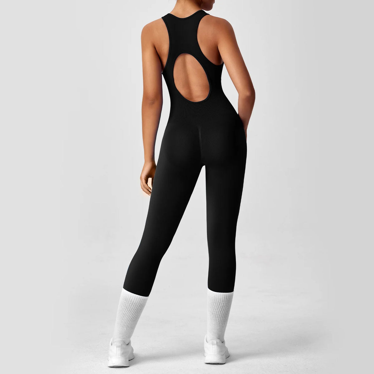 Peach-colored one-piece yoga bodysuit with booties, designed for comfortable exercise, featuring seamless construction for a sleek look.