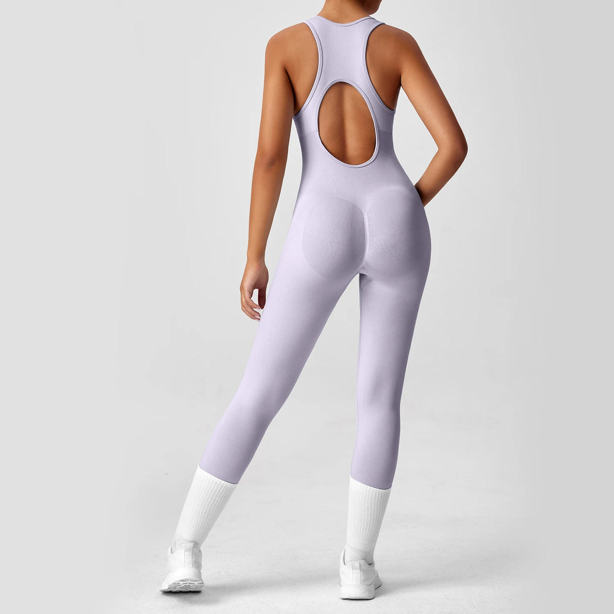 One-piece peach-colored yoga bodysuit with matching boot, designed by Corporación Turística, displayed on a neutral background.