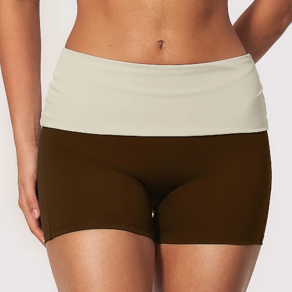 Navy blue women's yoga shorts with fold-over waistband and effect detail, by Corporación Turística, shown on a white background.