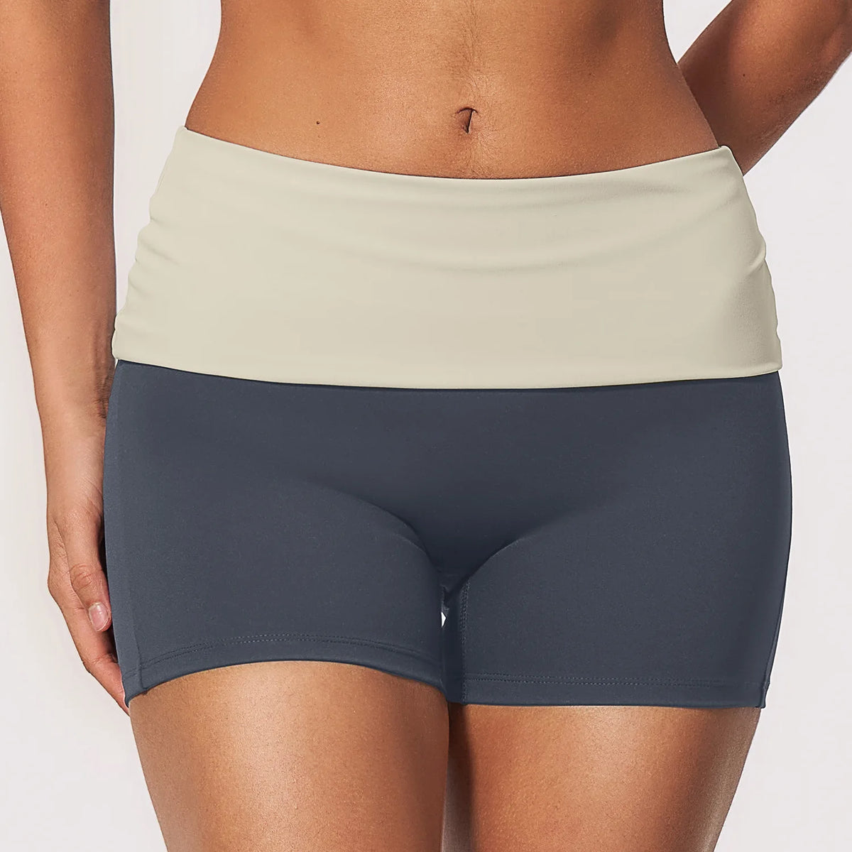 Navy blue women's yoga shorts with foldable waistband and effect le, made by Corporación Turística, suitable for active wear.
