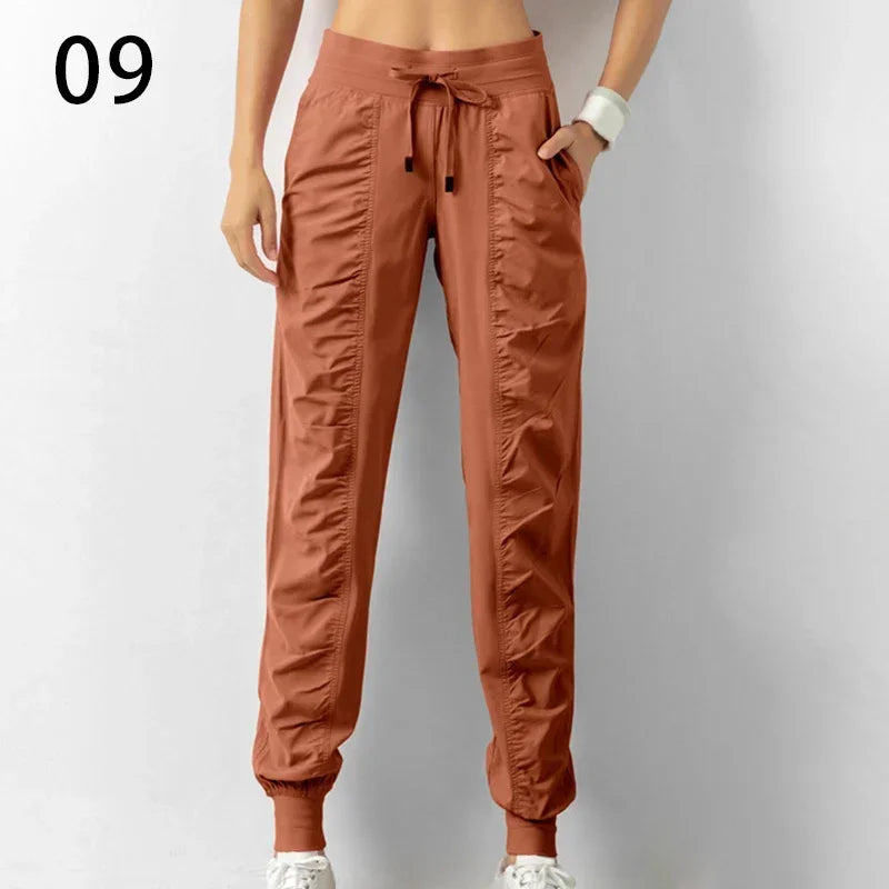 Navy blue women's athletic jogger pants with drawstring, made of soft fabric, featuring relaxed fit and elastic waistband.
