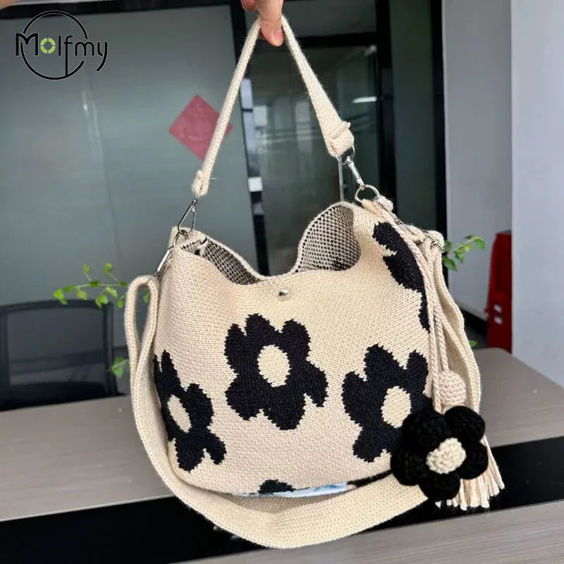 Handmade black crochet handbag with colorful floral details, crafted by Corporación Turística, featuring a stylish and unique design.