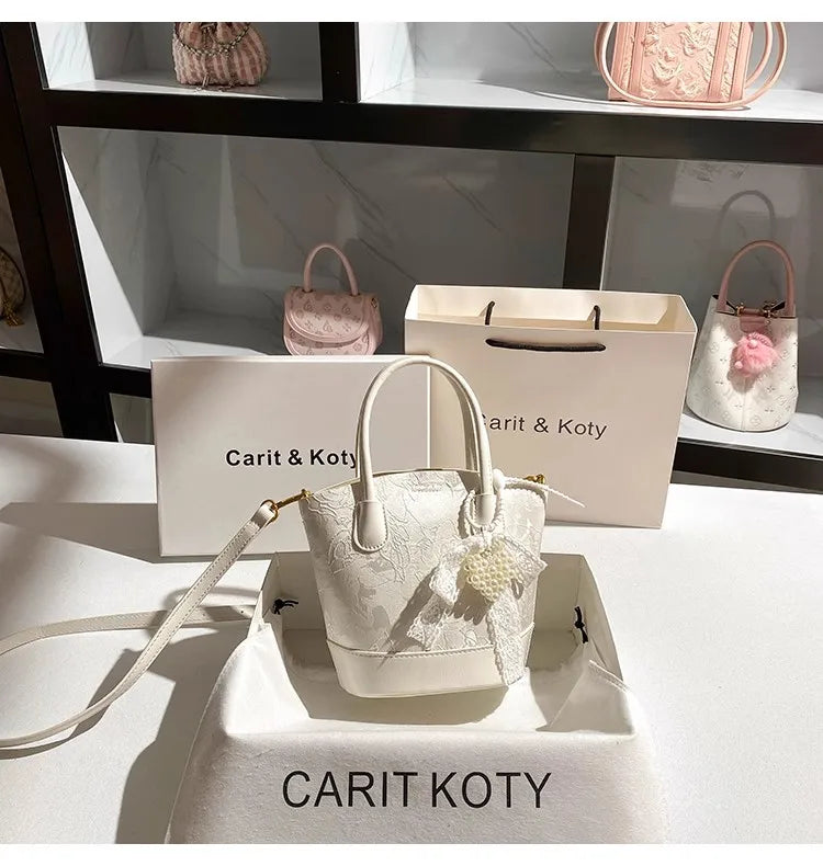 Luxury white embroidered cube-shaped handbag by Corporación Turística, stylish and fashionable with intricate embroidery details.