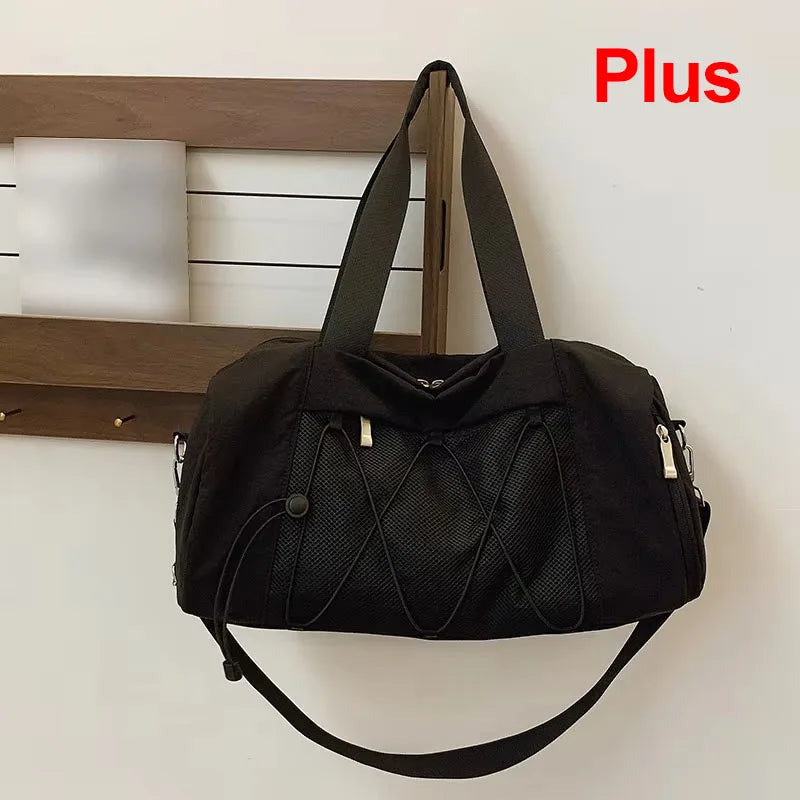 Black gym and travel bag for women and men by Corporación Turística, showing a spacious, durable fabric design with handles.