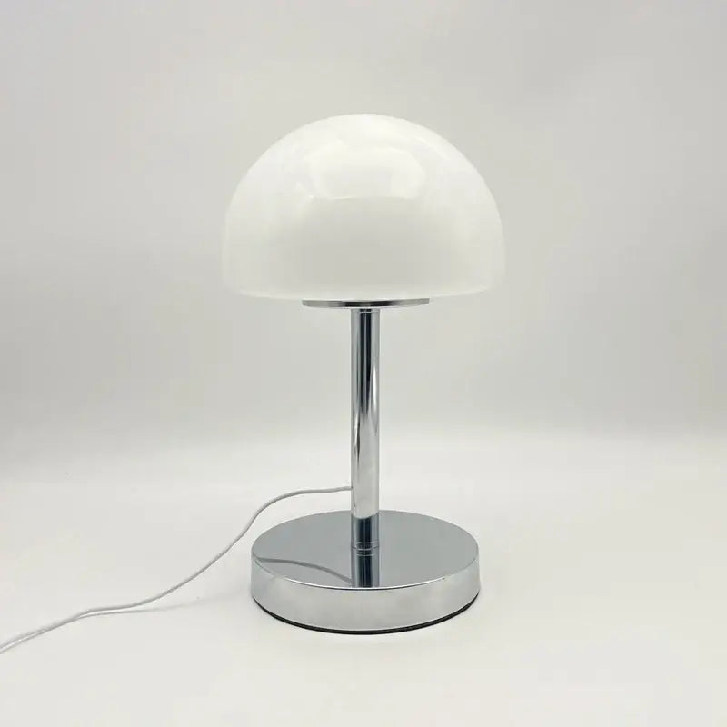 Orange glass table lamp with mushroom-shaped shade and decorative base, by Corporación Turística.