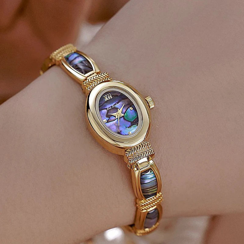 Gold oval-faced women's wristwatch by Corporación Turística with elegant design and matching gold jewelry box.