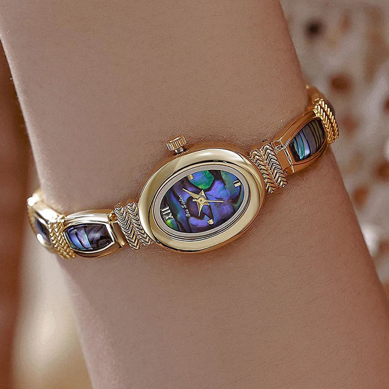 Gold oval-faced women's wristwatch by Corporación Turística with a sleek design and elegant bracelet.