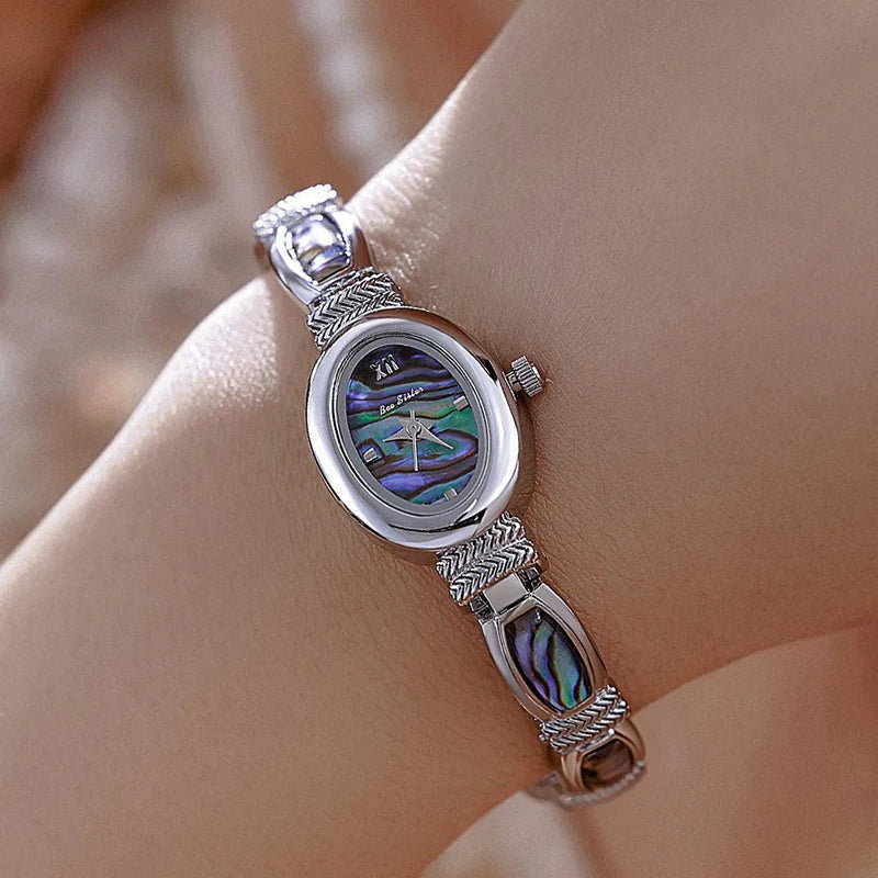 Gold oval-faced women's wristwatch by Corporación Turística with elegant design and matching presentation box.