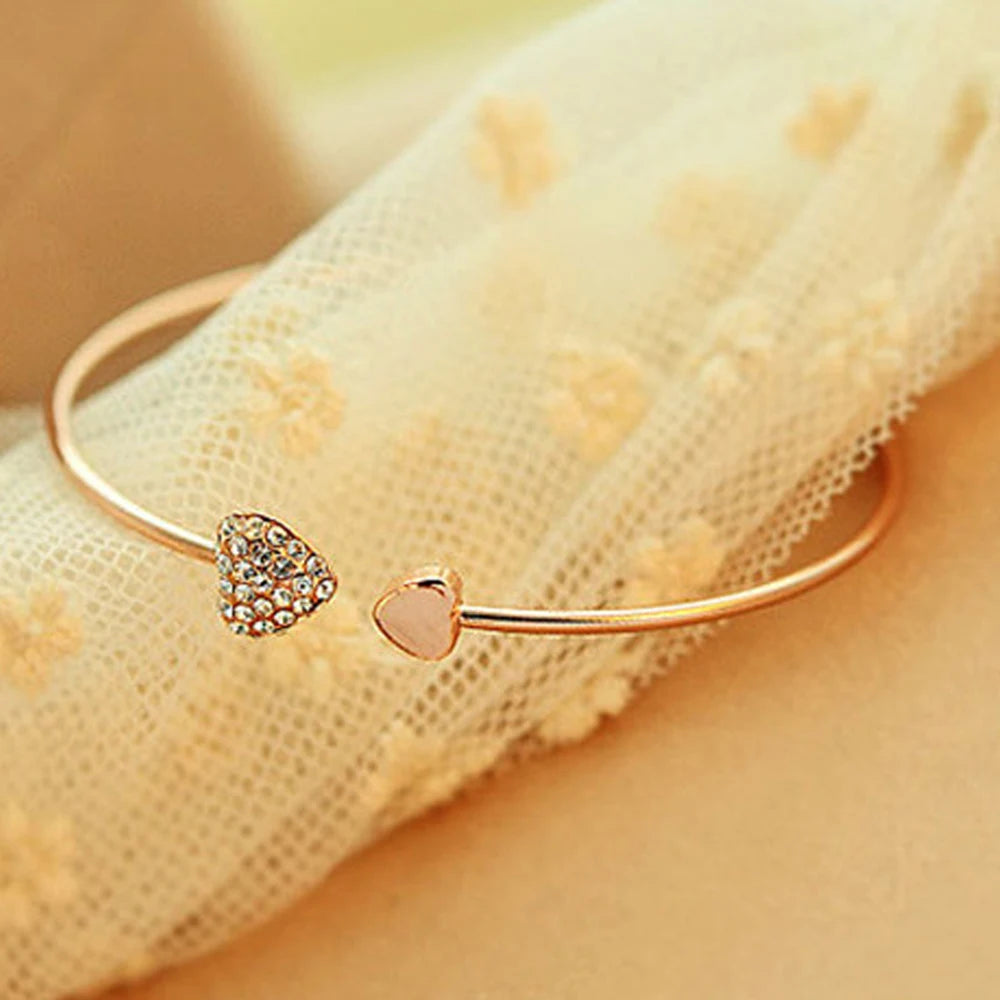 Gold double C bangle bracelet by Corporación Turística, elegant open cuff jewelry with a sleek design and shiny finish.