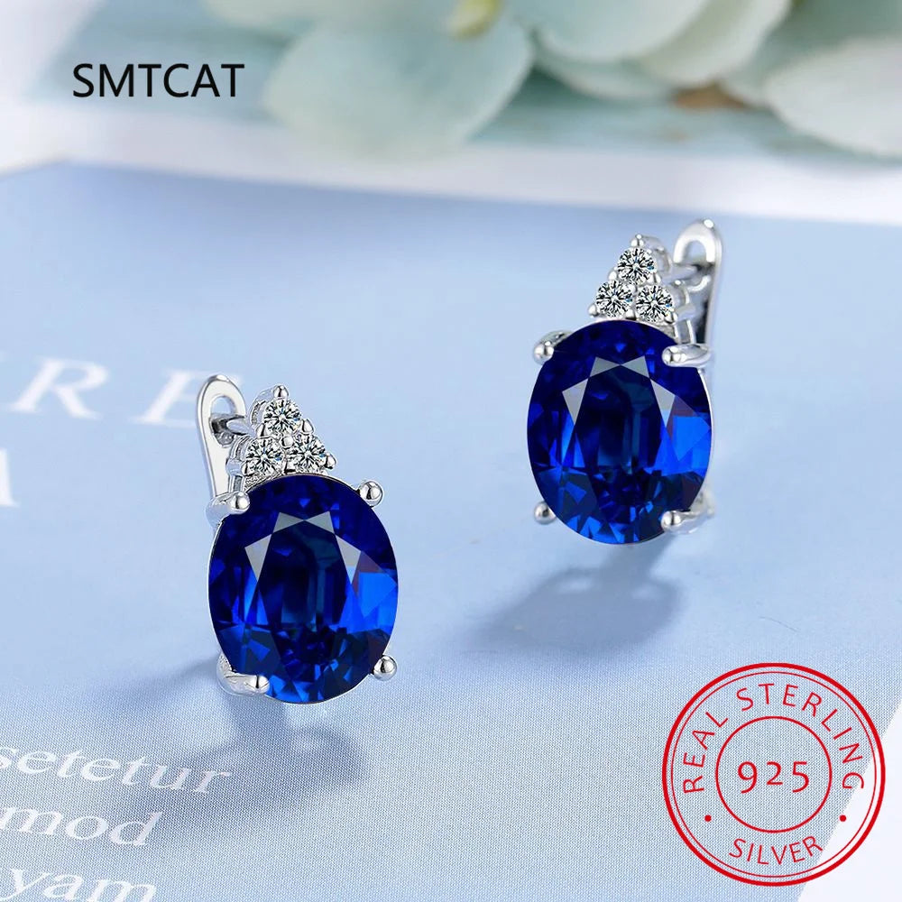 Sterling silver hoop earrings with blue sapphire accents, featuring elegant and vibrant design for sophisticated style.