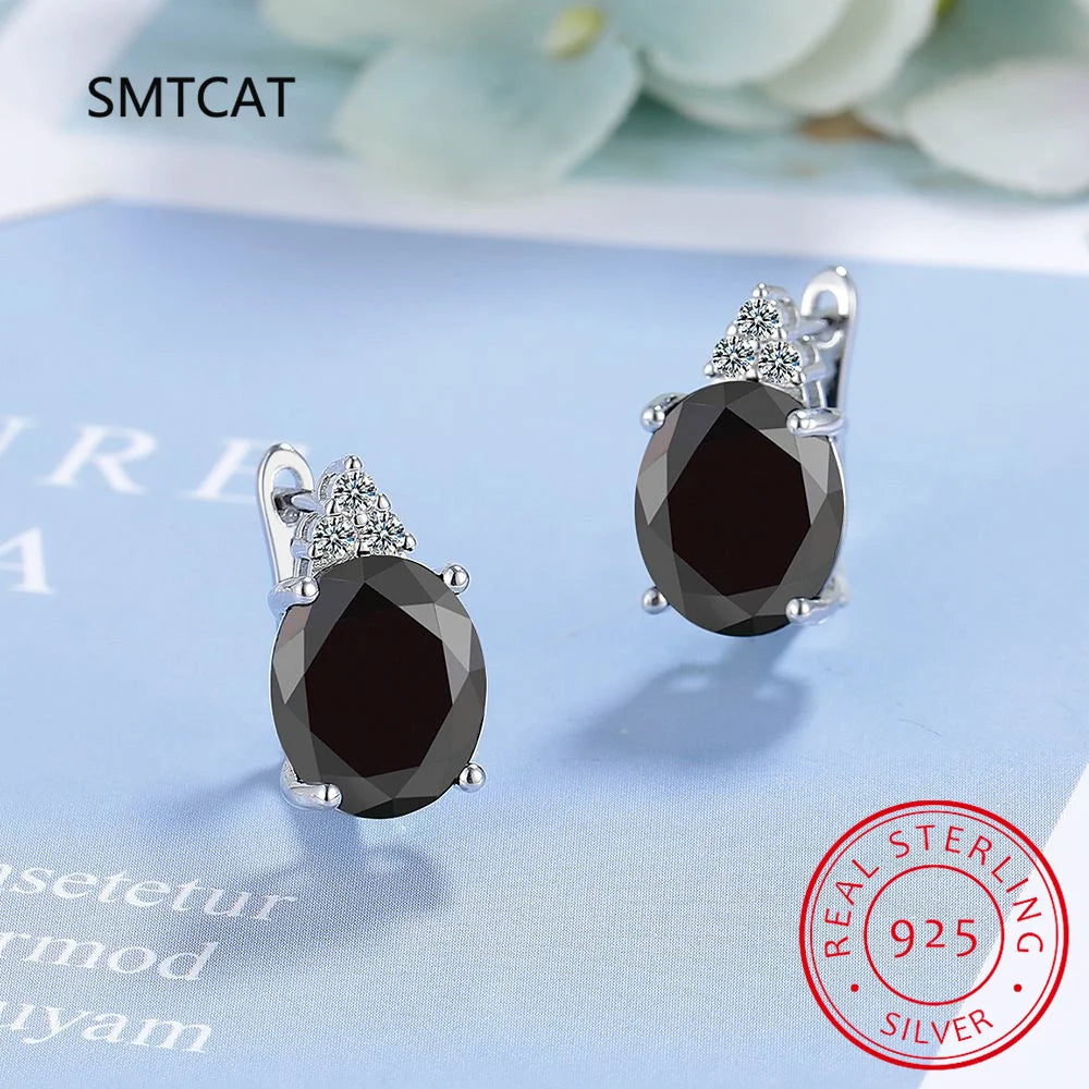 Sterling silver hoop earrings with blue sapphire accents, featuring elegant design and vibrant gemstone details.