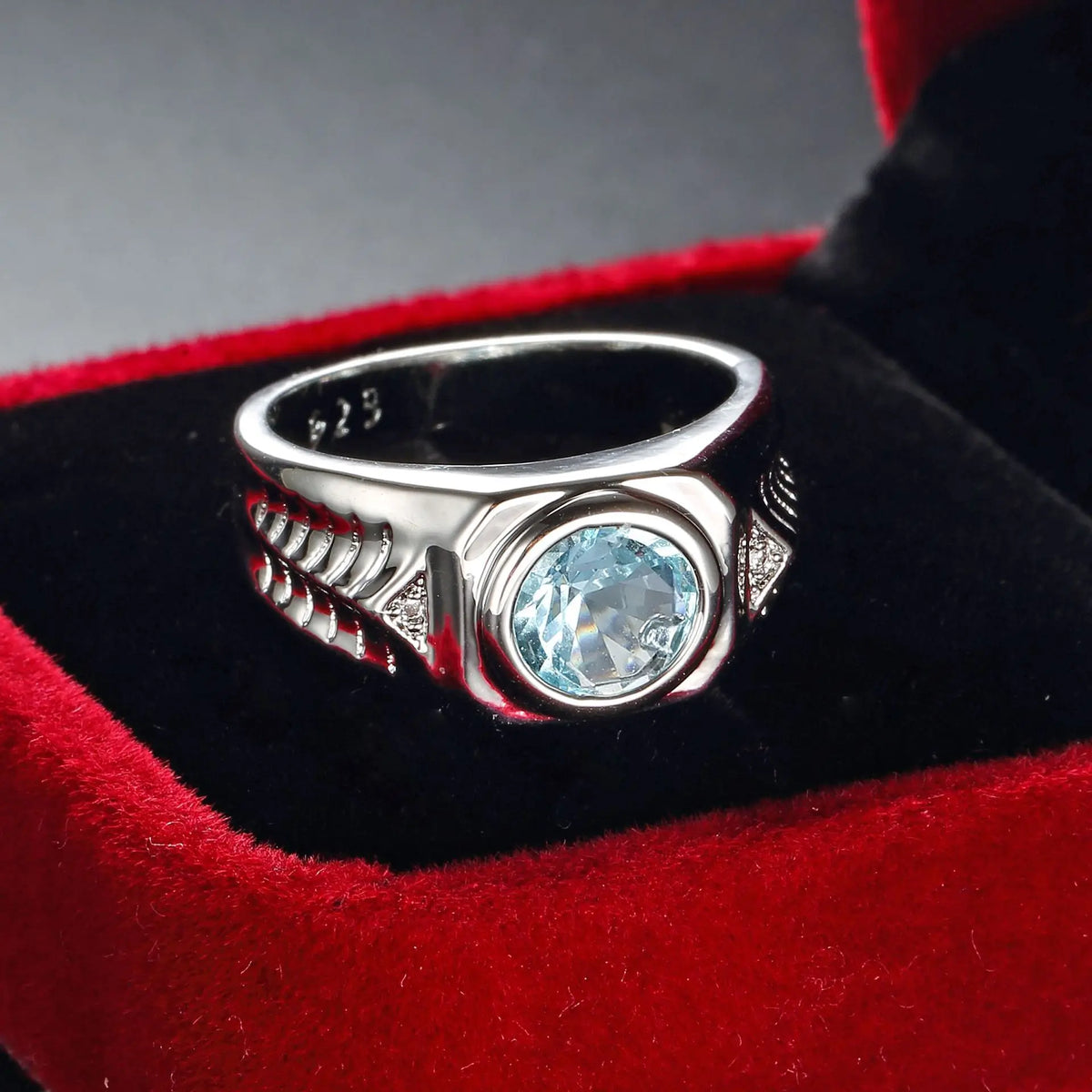 Silver ring with blue cubic zirconia and aquamarine gemstones showing intricate design and sparkling stones.