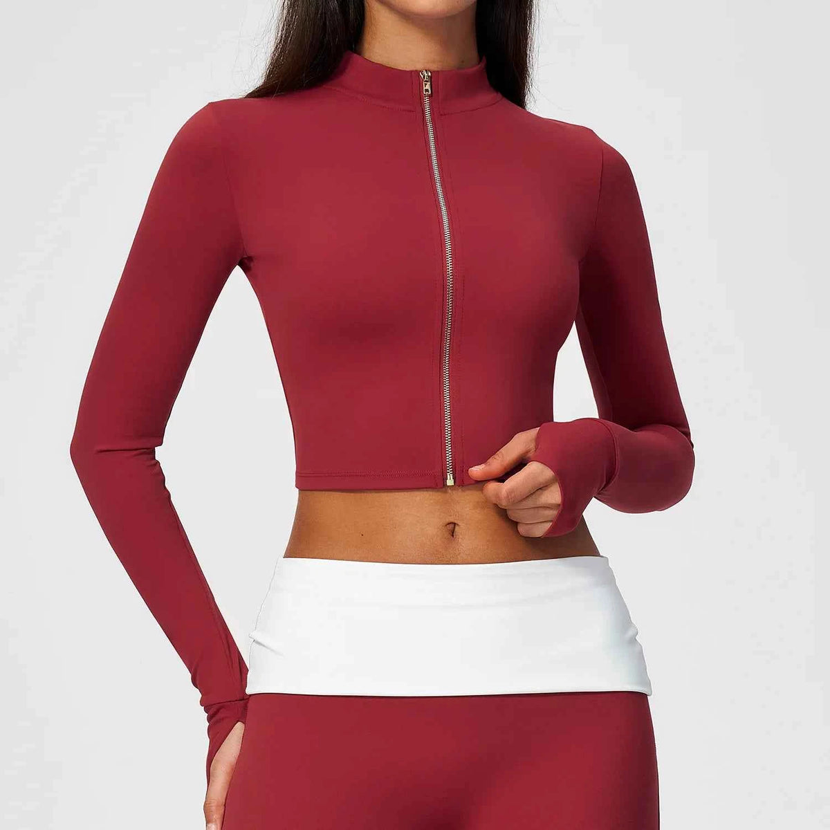 Pomegranate red long-sleeve women's sports T-shirt with zipper from Corporación Turística, shown on a mannequin.