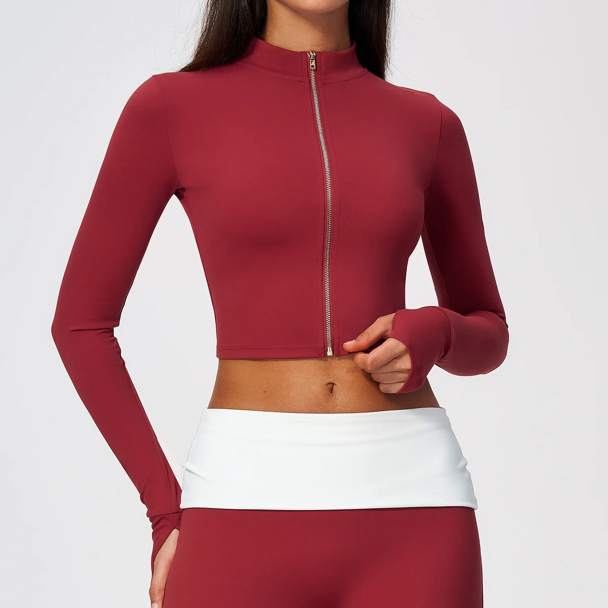 Red long-sleeve women's sports T-shirt with front zipper from Corporación Turística, shown on a mannequin.