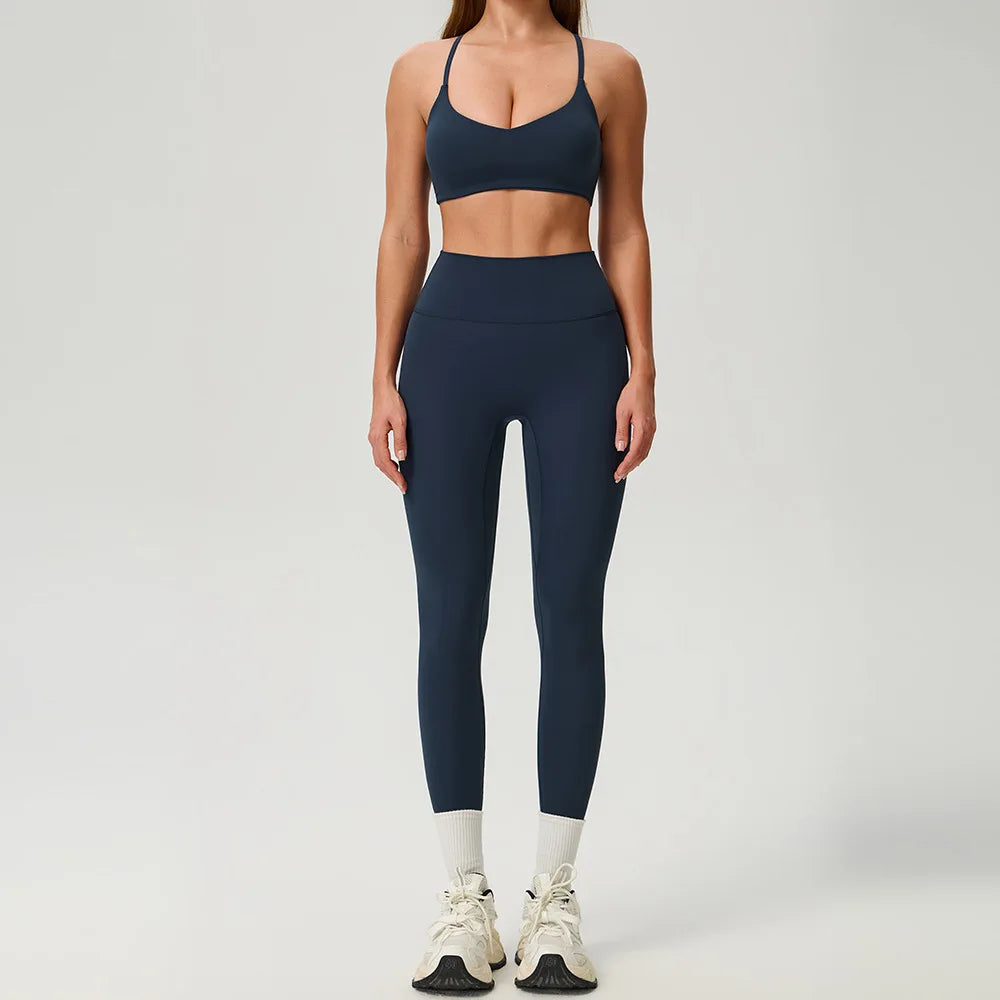 Black 2-piece women's sports set by Corporación Turística, featuring a sporty top and matching leggings for active wear.