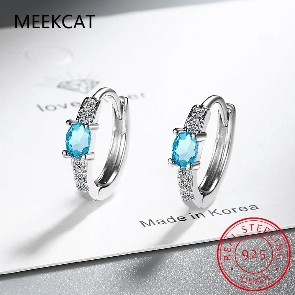 Silver 925 hoop earrings with blue sapphire gemstones, featuring a elegant and polished design.
