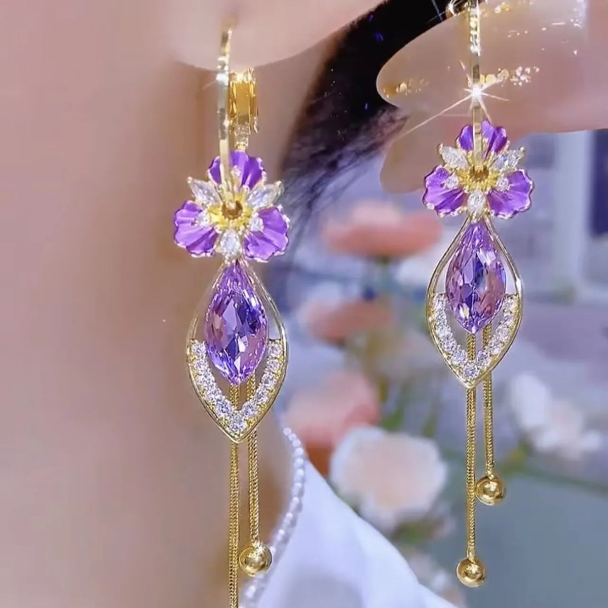 Butterfly pendant earrings with crystal and pearl accents, featuring elegant dangling design from Corporación Turística.