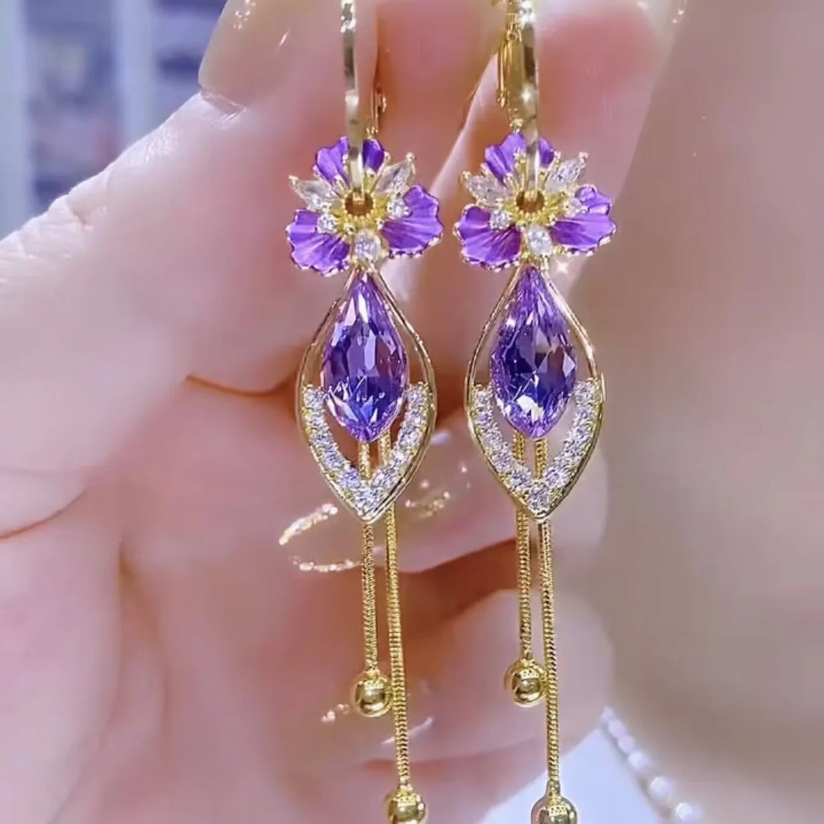 Elegant butterfly pendant earrings with crystal and pearl accents, crafted by Corporación Turística.