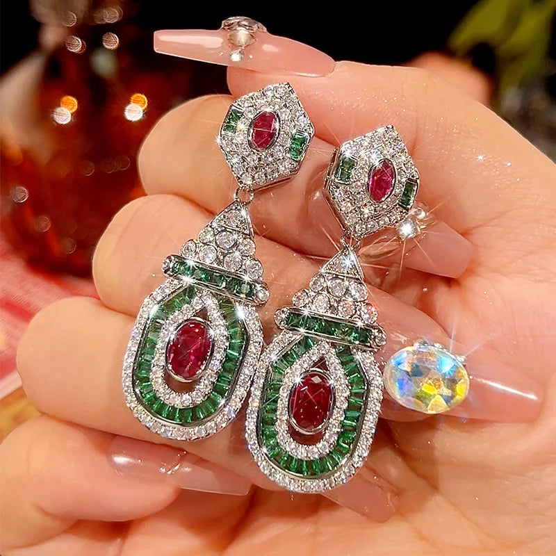 Vintage style dangling earrings featuring red studs, perfect for a fashionable and trendy look by Corporación Turística.