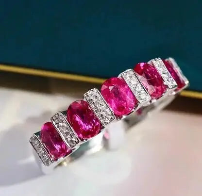 Elegant white cubic zirconia ring for women, luxurious jewelry piece with a red band, by Corporación Turística.