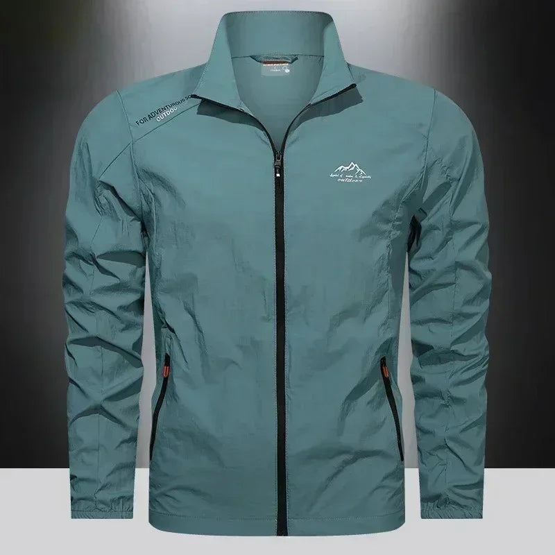 Blue men's UPF100+ ultralight summer windbreaker jacket with pockets, designed for outdoor UV protection by Corporación Turística.