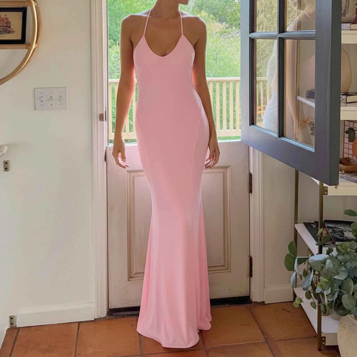 Pink sleeveless maxi evening dress with a halter neckline by Corporación Turística, form-fitting and elegant for special occasions.