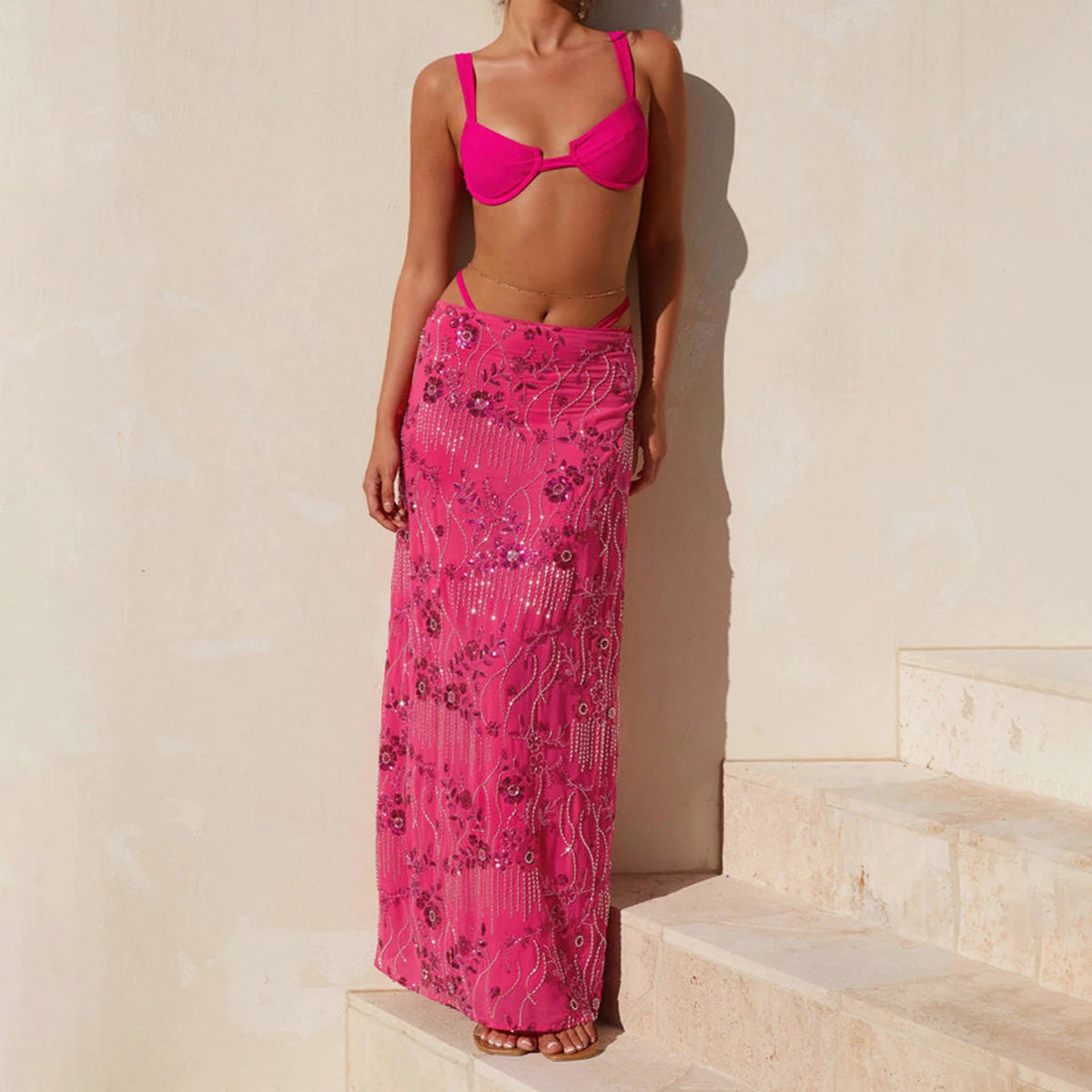 Elegant long women's skirt with sequins and beads in pink, featuring a flowing design and detailed embellishments.