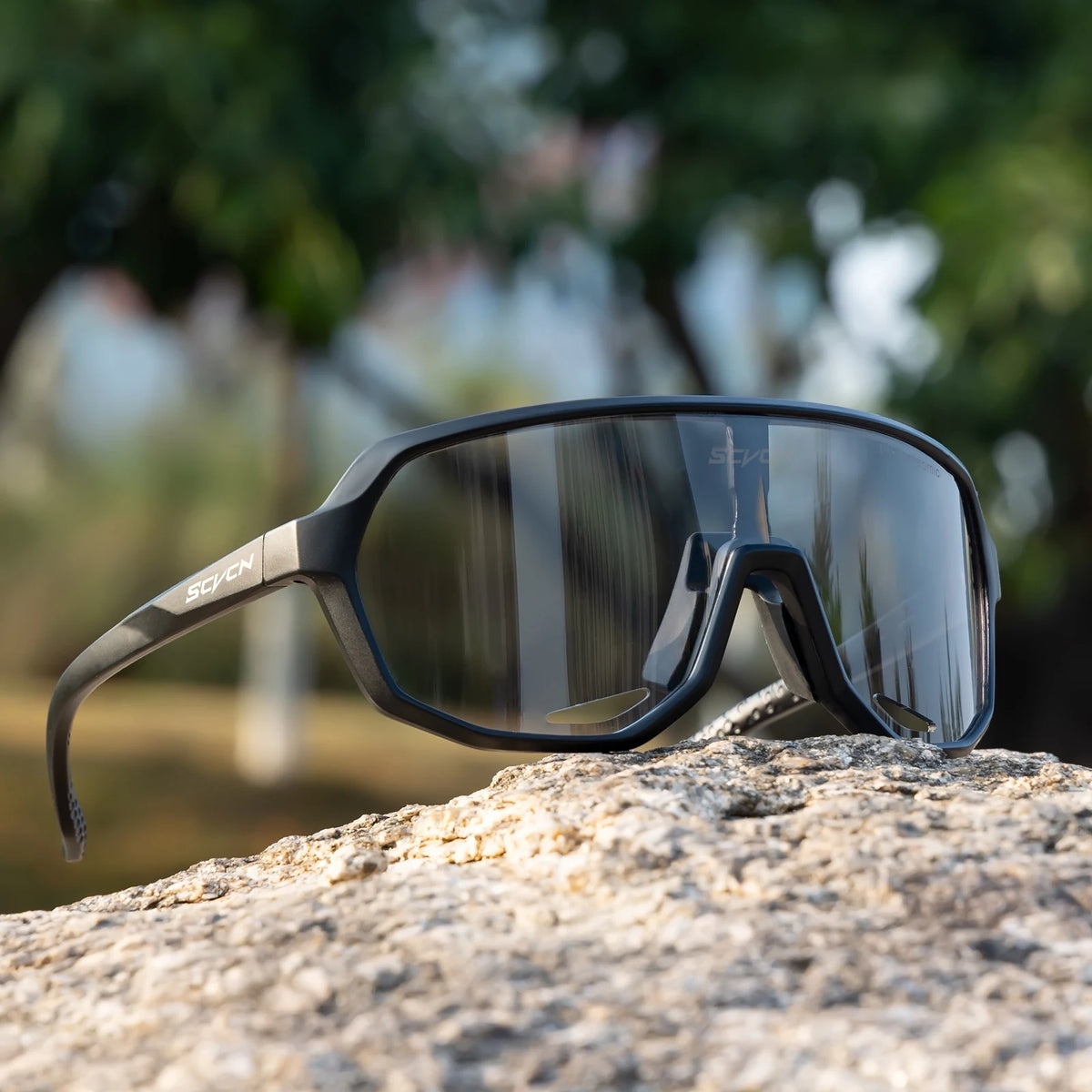 Photochromic cycling glasses SCVCN by Corporación Turística with tinted lenses and sporty frame, designed for outdoor cycling.