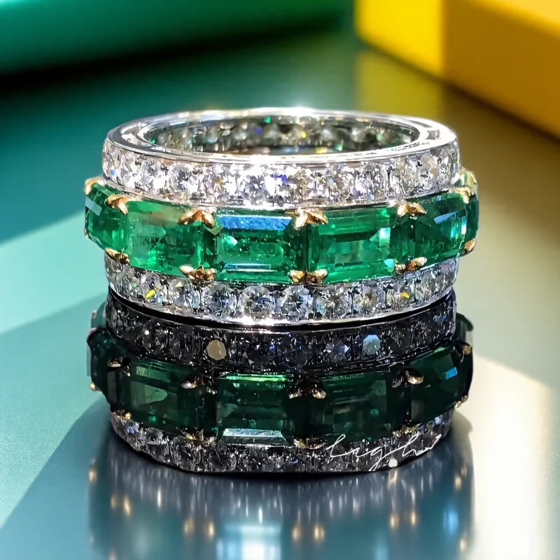 Silver wedding rings with square green design and full cubic zirconia from Corporación Turística, close-up of the rings' intricate details.