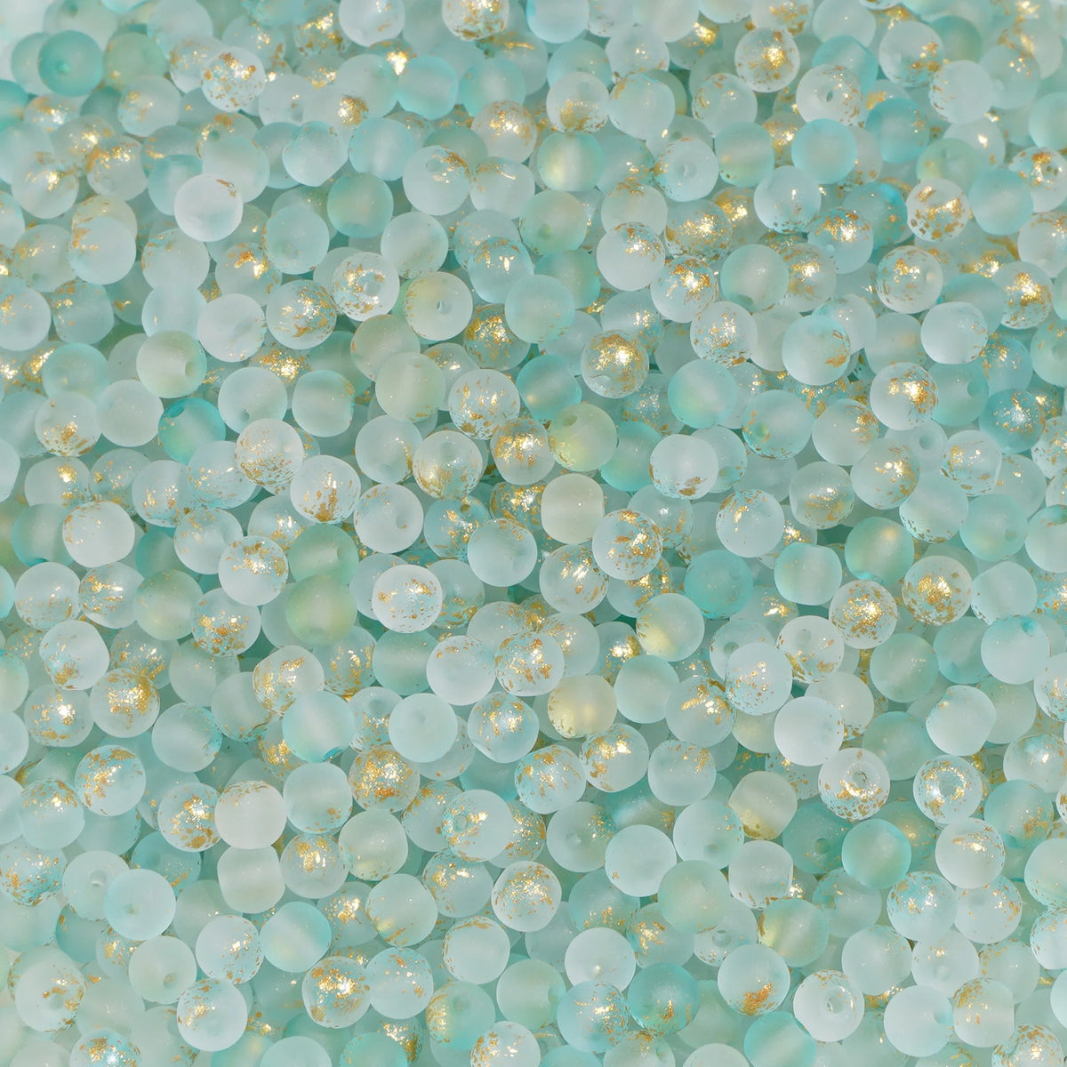 Set of 100 gold-splashed glass rice beads from Corporación Turística, 4mm, ideal for jewelry making or craft projects.